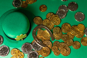 St Patrick symbols, gold coins, horseshoe, shamrocks and leprechaun hats. Copy space.