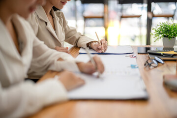 Two business colleagues sit at a table in the office and work together to review a marketing plan, audit accounts, work together to write a project plan.