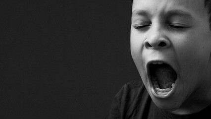 little boy yawning with open mouth on black background with people stock image stock photo - obrazy, fototapety, plakaty
