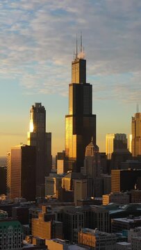 Urban Cityscape of Chicago Loop at Sunset in Frosty Winter Evening. Golden Hour. Aerial View. United States of America. Drone Flies Sideways. Medium Shot. Vertical Video