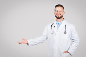 Inviting male doctor gesturing with open hand, free space