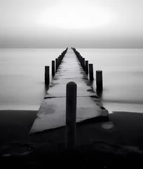 Türaufkleber Long exposure of a jetty on a beach at sunset in black and white © Iman