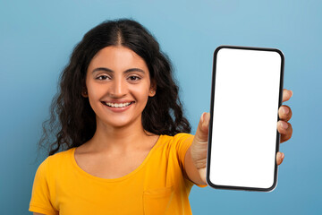 Smiling young indian woman student showing phone blank screen