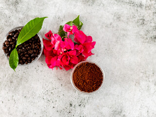 Top shot of coffee powder, flower and leaves over the roasted beans.
