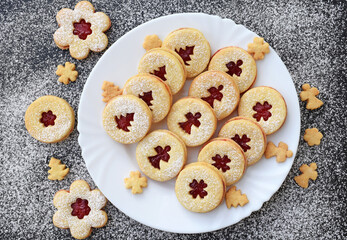 Linzer cookies on a plate and around it