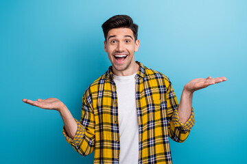 Photo of excited impressed man dressed yellow plaid shirt showing arms scales empty space isolated...