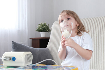 A little girl, a child of European appearance, blond hair, wearing an inhaler mask. Treatment of...