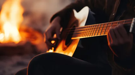 Gordijnen Close-up of an acoustic guitar in a musician's lap, blurred background of a bonfire © Татьяна Креминская