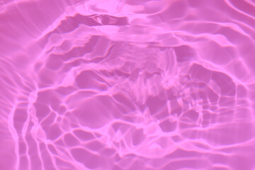 Pink water bubbles on the surface ripples. Defocus blurred transparent purple colored clear calm water surface texture with splash and bubbles. Water waves with shining pattern texture background.