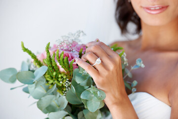 Diamond, wedding ring and hands of bride with bouquet, flowers and pride for commitment, celebration or marriage. Bridal, aesthetic and woman closeup with engagement jewelry or floral arrangement - obrazy, fototapety, plakaty