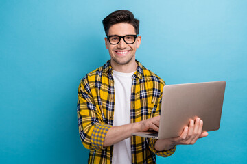 Portrait of optimistic smart guy with stubble wear checkered shirt in glasses hold laptop in arm...