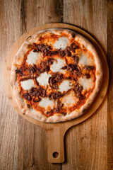 Cheese pizza with delicious toppings of mozzarella and cream cheese on a wooden stand