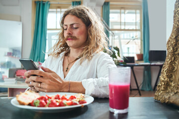 Caucasian handsome man with makeup eating fresh croissant with strawberry
