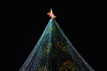 Festive Christmas Tree Decorated With Colorful Ornaments On A Black Background