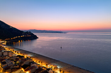 The city of Scilla Calabria Italy. Elevated view of the Marina Grande beach at sunset and the Strait of Messina - obrazy, fototapety, plakaty