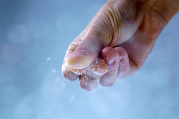 Man adding salt to boiling water in saucepan. Selective focus