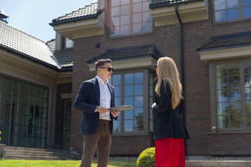 Blonde businesswoman listens to real estate agent house description. Female customer inspects new...