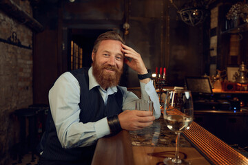 Happy smiling drunk man with glass in the bar