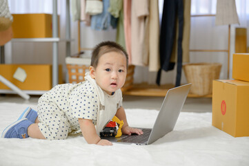 A little Asian boy crawled on the floor in the living room. A baby is playing in the children's room of the house.