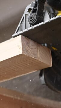 Master cuts the board with a circular saw in the workshop. . Vertical video. 