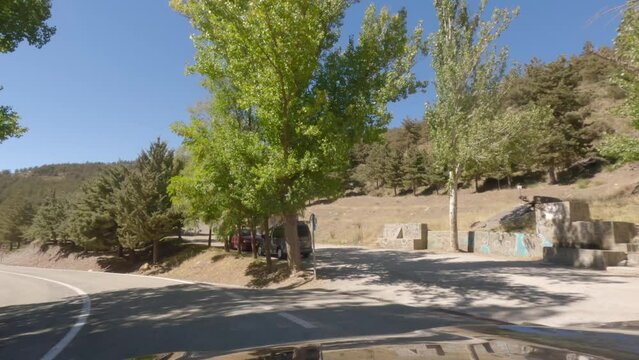 First person view, FPV, from dashcam of car driving mountain road from Calar Alto Observatory to Tabernas Desert in Almeria, Andalusia, Spain, Europe. Road trip in POV, stopping at water spring