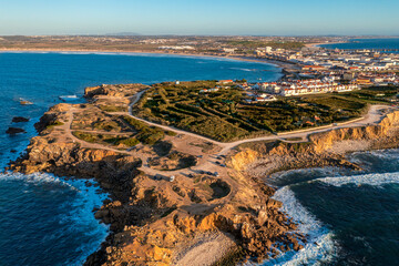 Peniche peninsula with high cliffs and ocean tide at sunset, Portugal