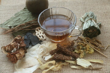 a glass cup of herbal juice or Jab-Liang juice with its herb ingredient. ingredients of Chinese...