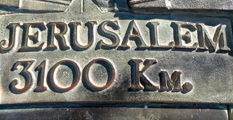 metal sign with the name of Jerusalem in Catalan with the kilometers from the province of...
