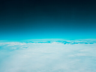 Low earth orbit above the horizon turquoise green space and white clouds