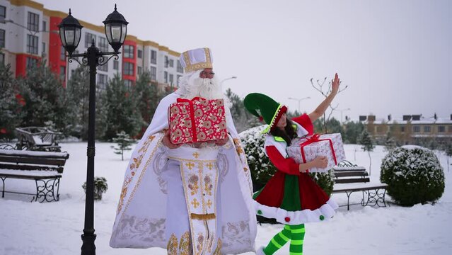 Santa and an elf are handing out gifts for the New Year holidays