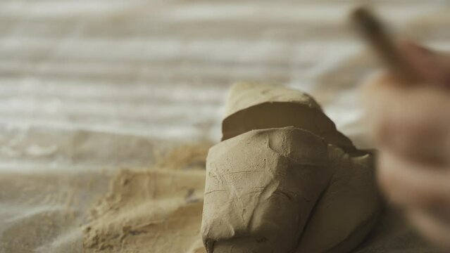 A woman cuts the clay into portions for further making of the craft. Close-up. Hobbies and creativity.