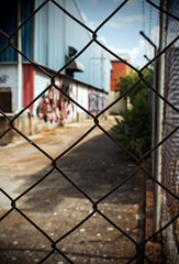 Industrial building on the outskirts, fence and graffiti - 692614936