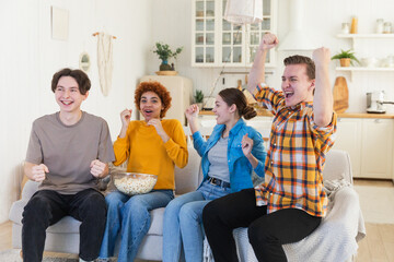Group of friends watching sport match soccer football game on tv. Happy football fans celebrating...