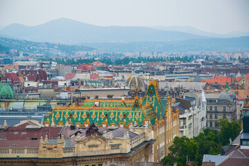 A panoramic aerial view of Budapest, highlighting the art nouveau painted tiled roof of the Hungarian Postal Savings Bank