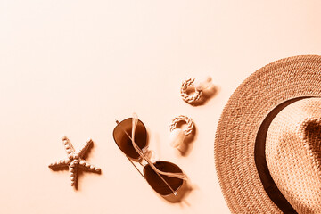 Flat lay with women's summer accessories on neutral background. Sunglasses, straw hat, earrings and...