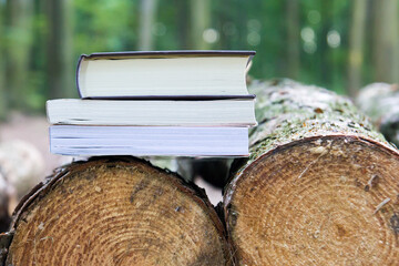 Three books lying on felled trees,  Save the trees - read e-books - 692623160