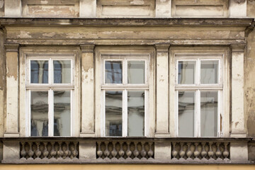 Fototapeta na wymiar Three ragged Windows on the facade of the old house