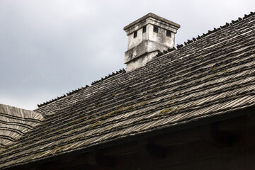 Wooden roof with chimney an old rural house - 692623717