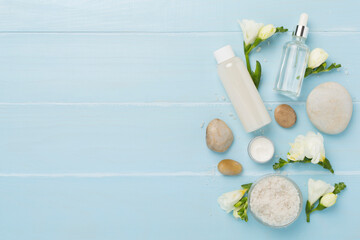 Flat lay with spa products and flowers on wooden background