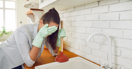 Sad woman grapples with a sink cleaning issue, attempting to unclog the basin and clutching a...