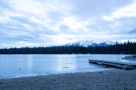 night photo of cold lake with ice and jetti some clouds