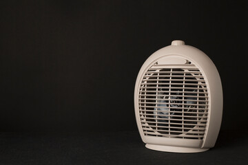Portable electric heater on black background