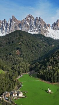 Spring landscape with shurch in Santa Magdalena village, Italian Dolomites Alps, in South Tyrol, Val di Funes, Italy. Vertical video