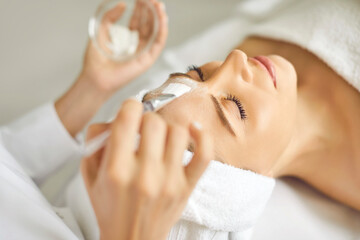 Woman getting professional facial treatment at spa and beauty salon. Beautician or cosmetologist...
