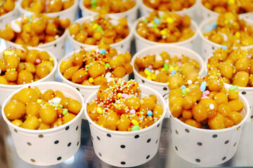 Cups filled with Struffoli, typical Neapolitan pastry consisting of many small balls of dough fried...