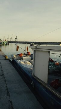 Fishing boats and ships in the port of Castellon in winter. Port cranes on the horizon. Red floats for nets. Port of El Grao. Spain