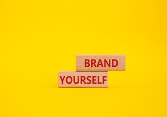 Brand yourself symbol. Concept word Brand yourself on wooden blocks. Beautiful yellow background....