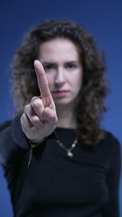 Close-up woman waving FINGER saying NO to camera by rejecting OFFER. stern serious body language of...