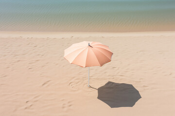 Simple peach fuzz beach umbrella casting a shadow on sand