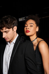 appealing multicultural elegant couple in evening attires posing together at cinema, Valentines day